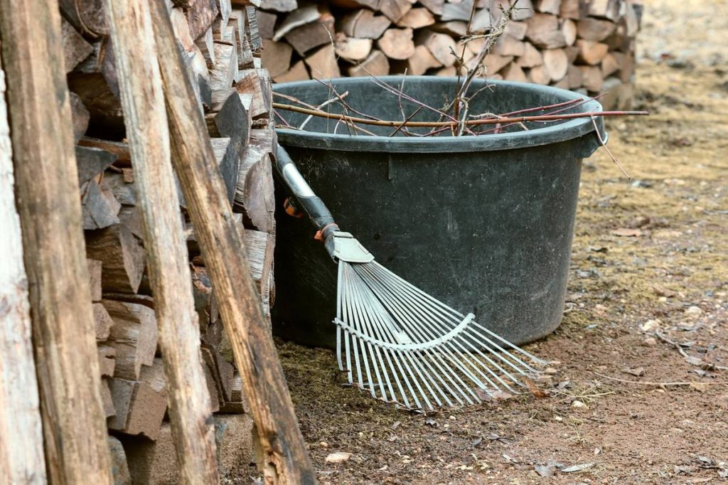 Bac, râteau et bois rangés au jardin pour l'hiver