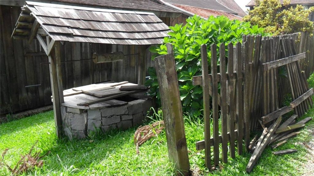 Puits couvert en bois dans un jardin clos