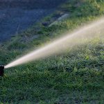 Arroseur escamotable projetant un jet sur un gazon