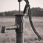 Pompe à eau en fonte au bord d'un champ